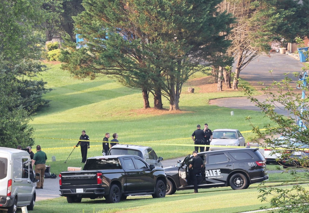 Investigators use a metal detector to collect evidence at the scene of a mass shooting, Sunday, June 1, 2025 in Hickory, N.C