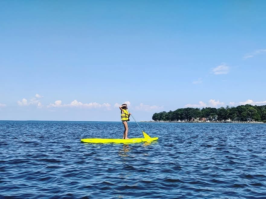 a kid on a yellow paddleboard