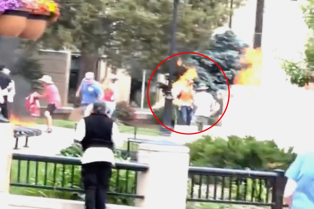 A man throwing an incendiary device at a group of people.