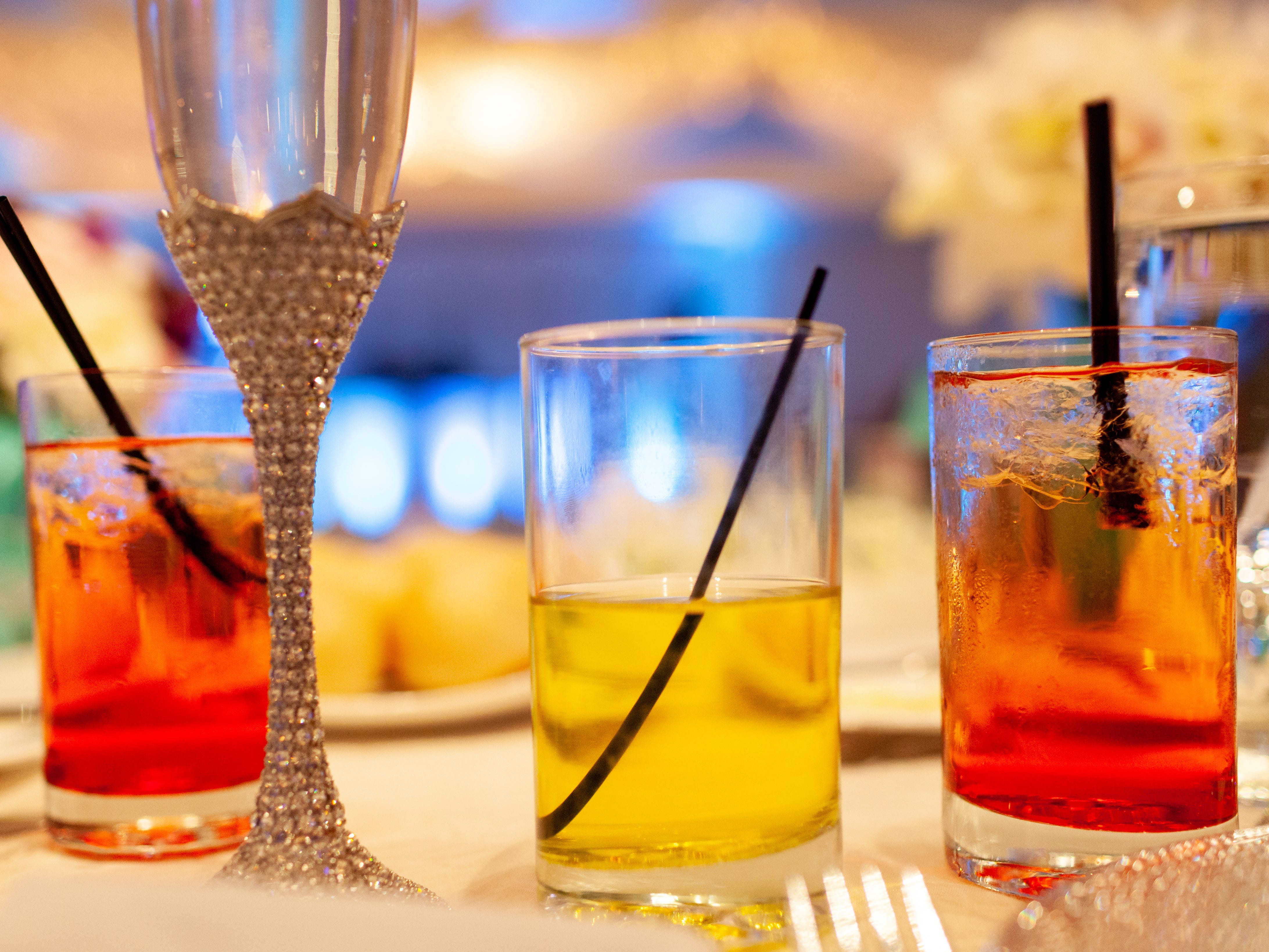 Cocktails and bedazzled Champagne glasses on a table.