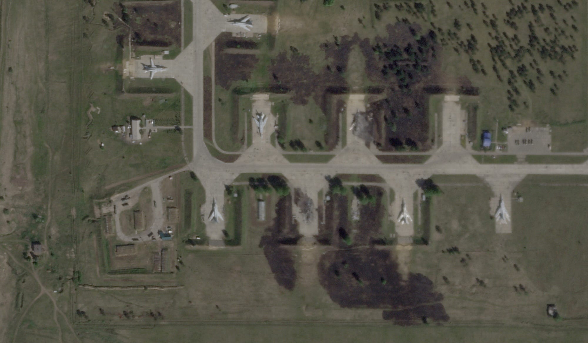 A satellite view shows military aircraft, some sitting destroyed, at an air base