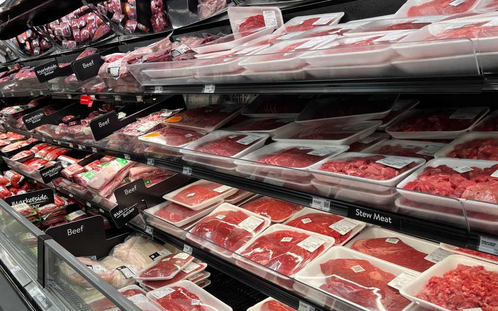 Various cuts of beef packaged in a supermarket meat display.