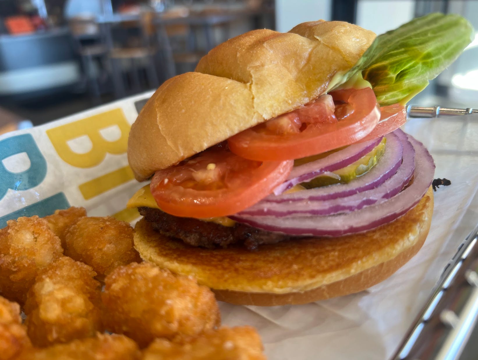 A classic burger from Smashburger, with a side of tater tots.