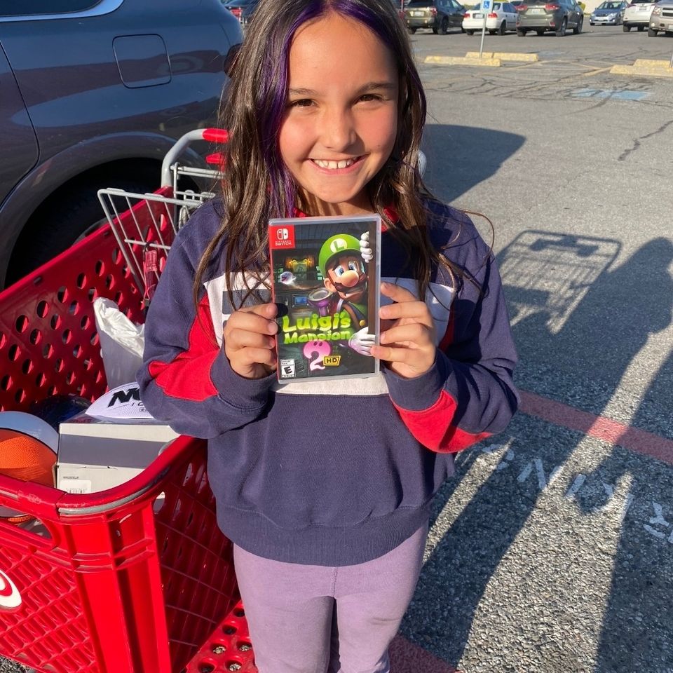 Girl holding Luigi's Mansion 2 Nintendo Switch game.