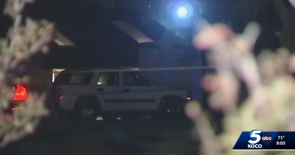 Nighttime image of a white SUV at a crime scene.