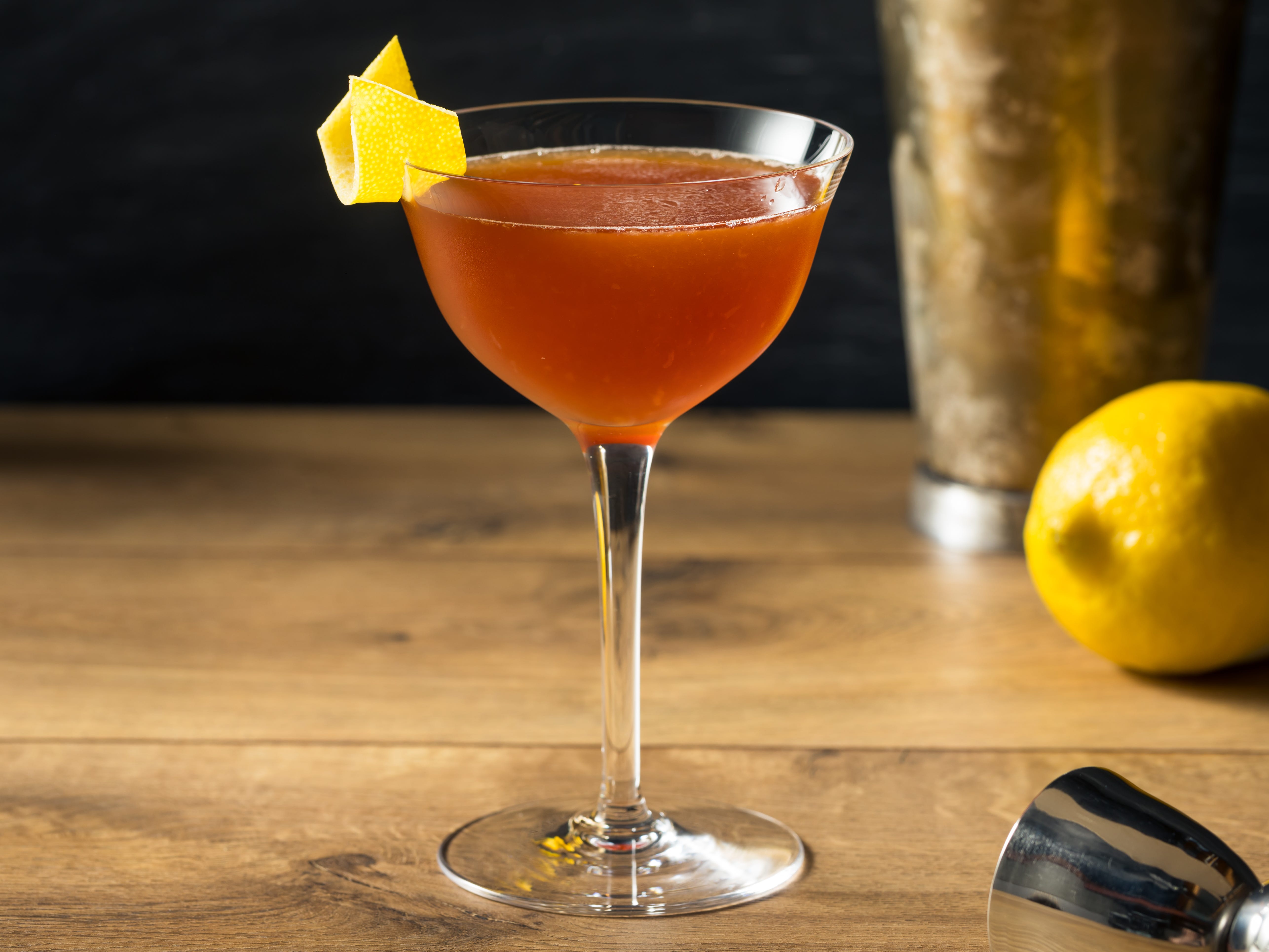 A whisky-based cocktail with a lemon skin on the rim that's twisted to look like a paper plane.