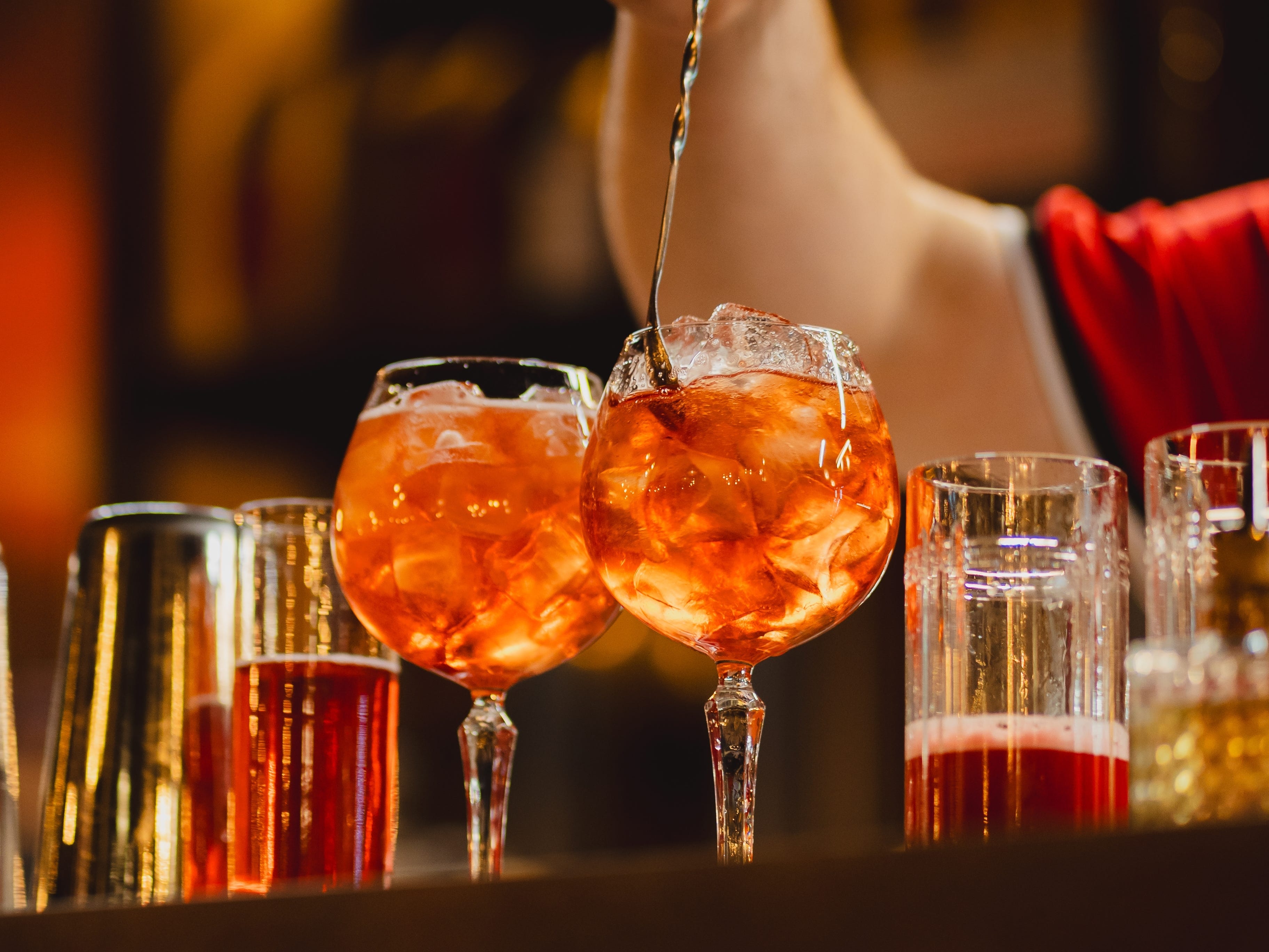 A bartender making two Aperol Spritz cocktails