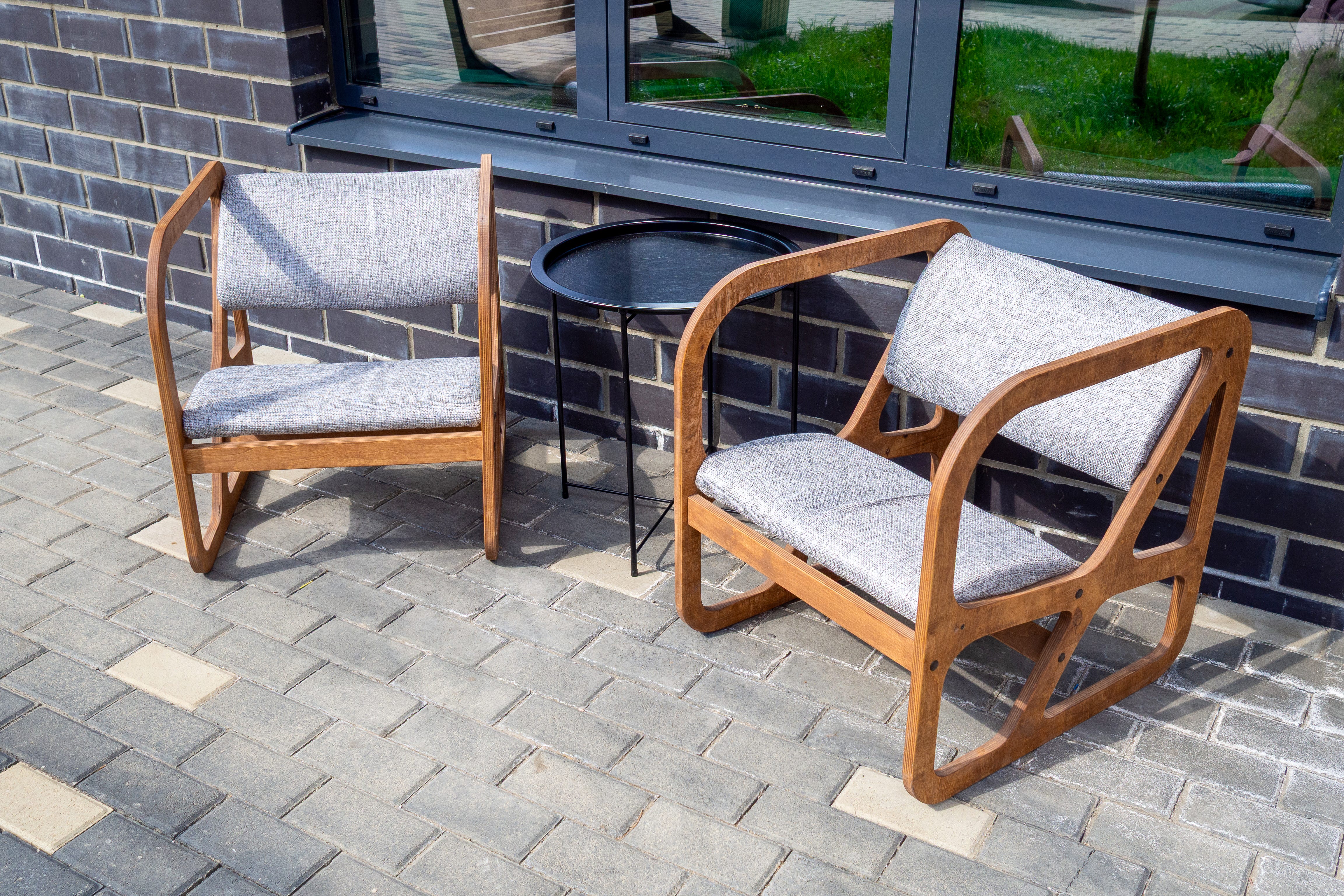 Wood chairs with cushions on brick patio