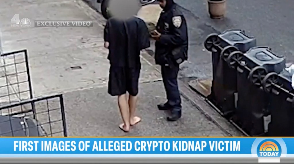 Video still of alleged crypto kidnapping victim speaking with a police officer.
