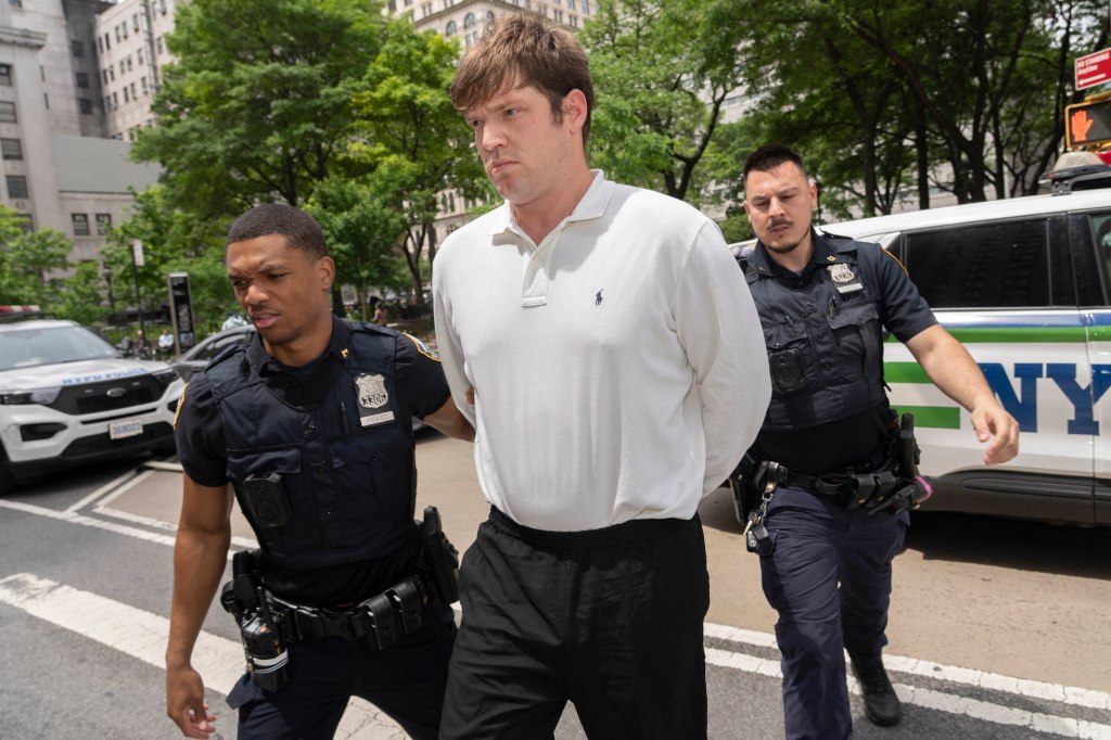 William Duplessie in handcuffs, escorted by two NYPD officers.