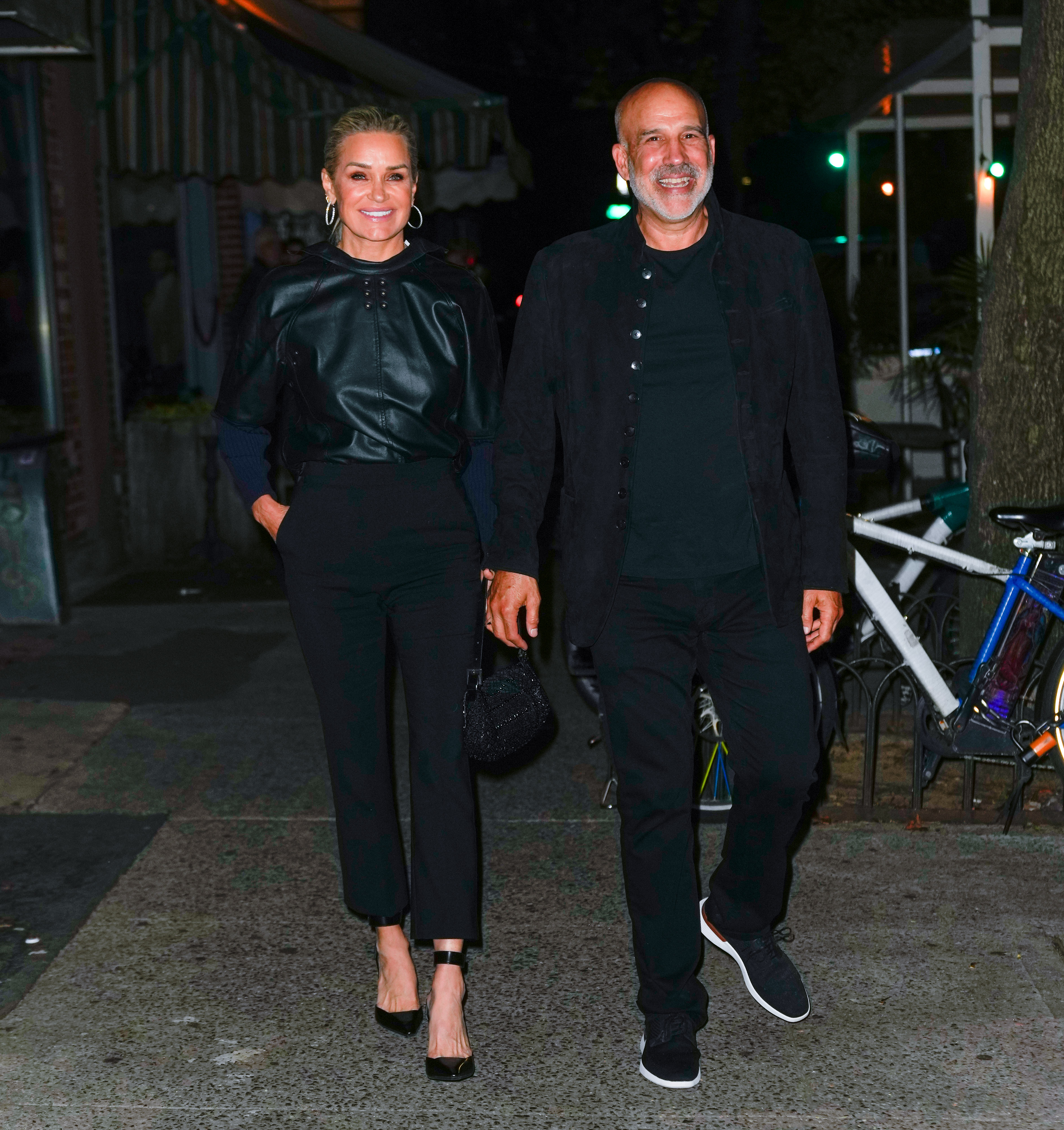 Yolanda Hadid and Joseph Jingoli wear black while walking outdoors. 
