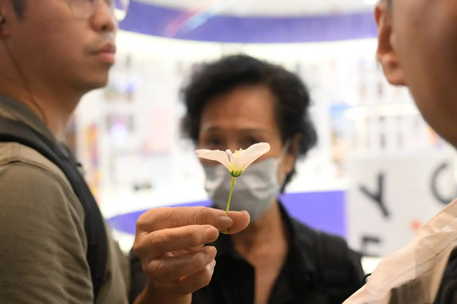 Police question a woman carrying a small white flower close to Victoria Park in Hong Kong's Causeway Bay district on June 4. People traditionally gathered there annually on June 4 to mourn the victims of China’s Tiananmen Square crackdown in 1989, but such demonstrations are now banned following a national security law imposed on the city in 2020.