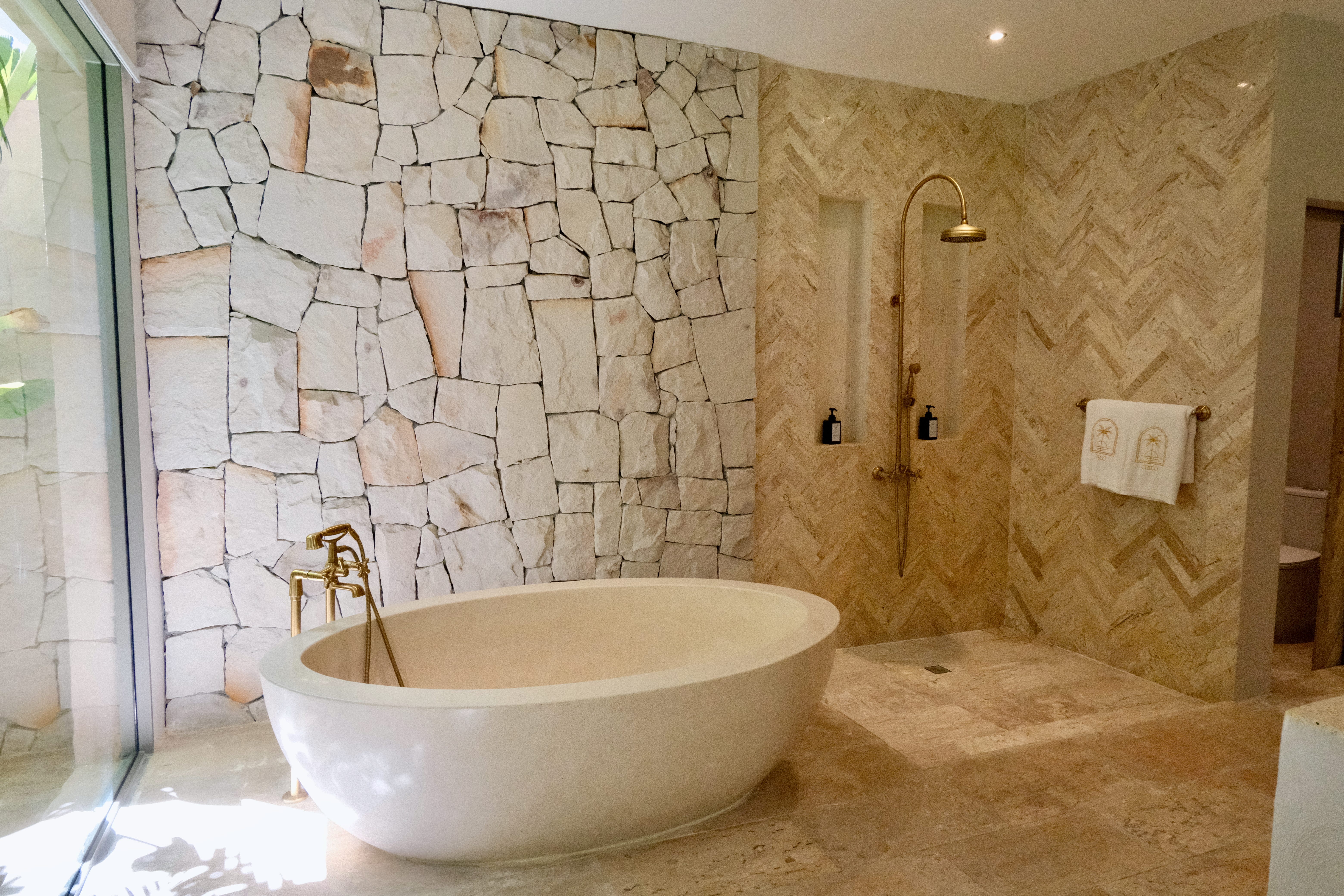 A bath tub and shower in one of the hotel rooms.