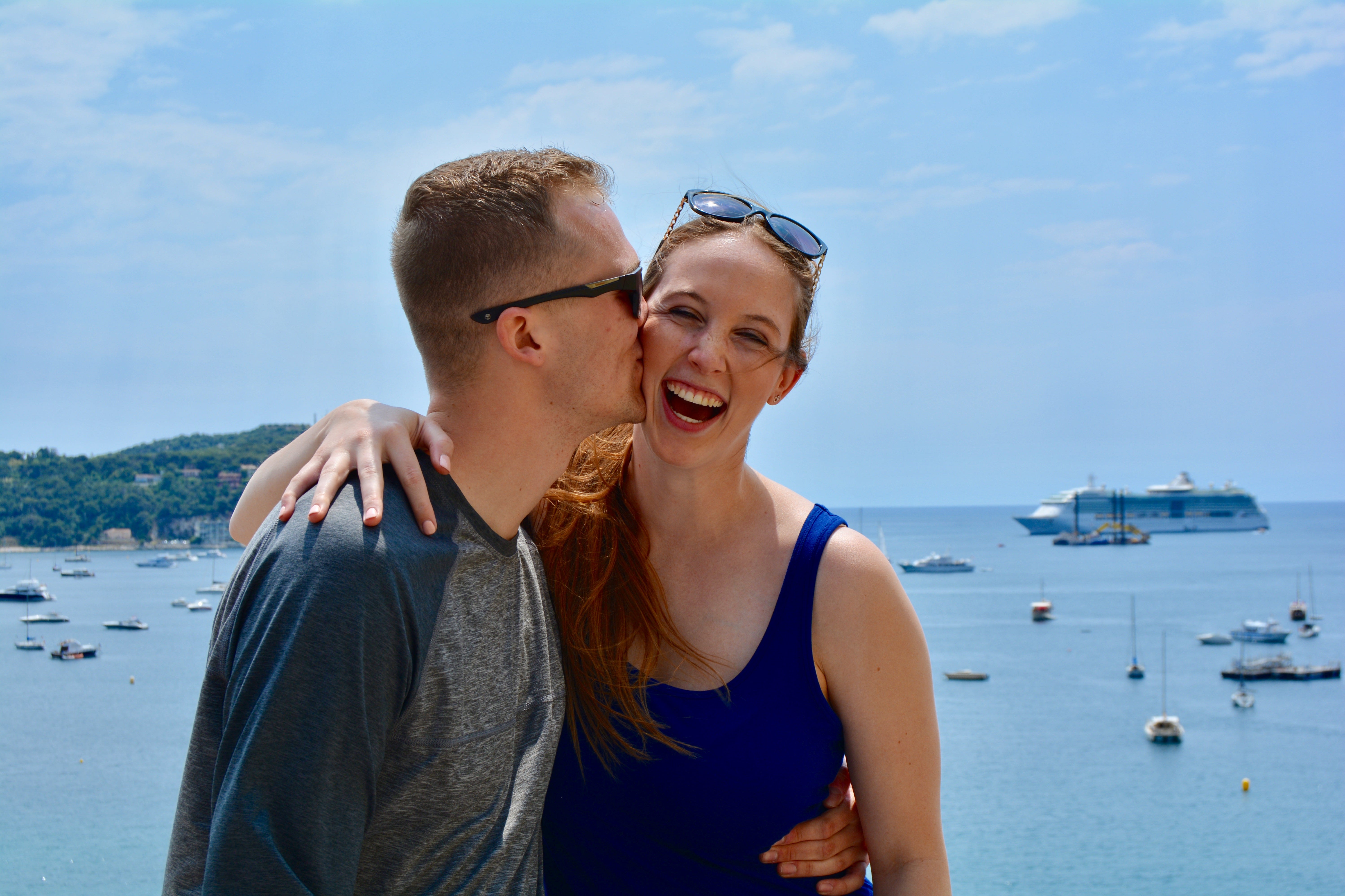 Author Allie Hubers being kissed on the cheek by her husband in France