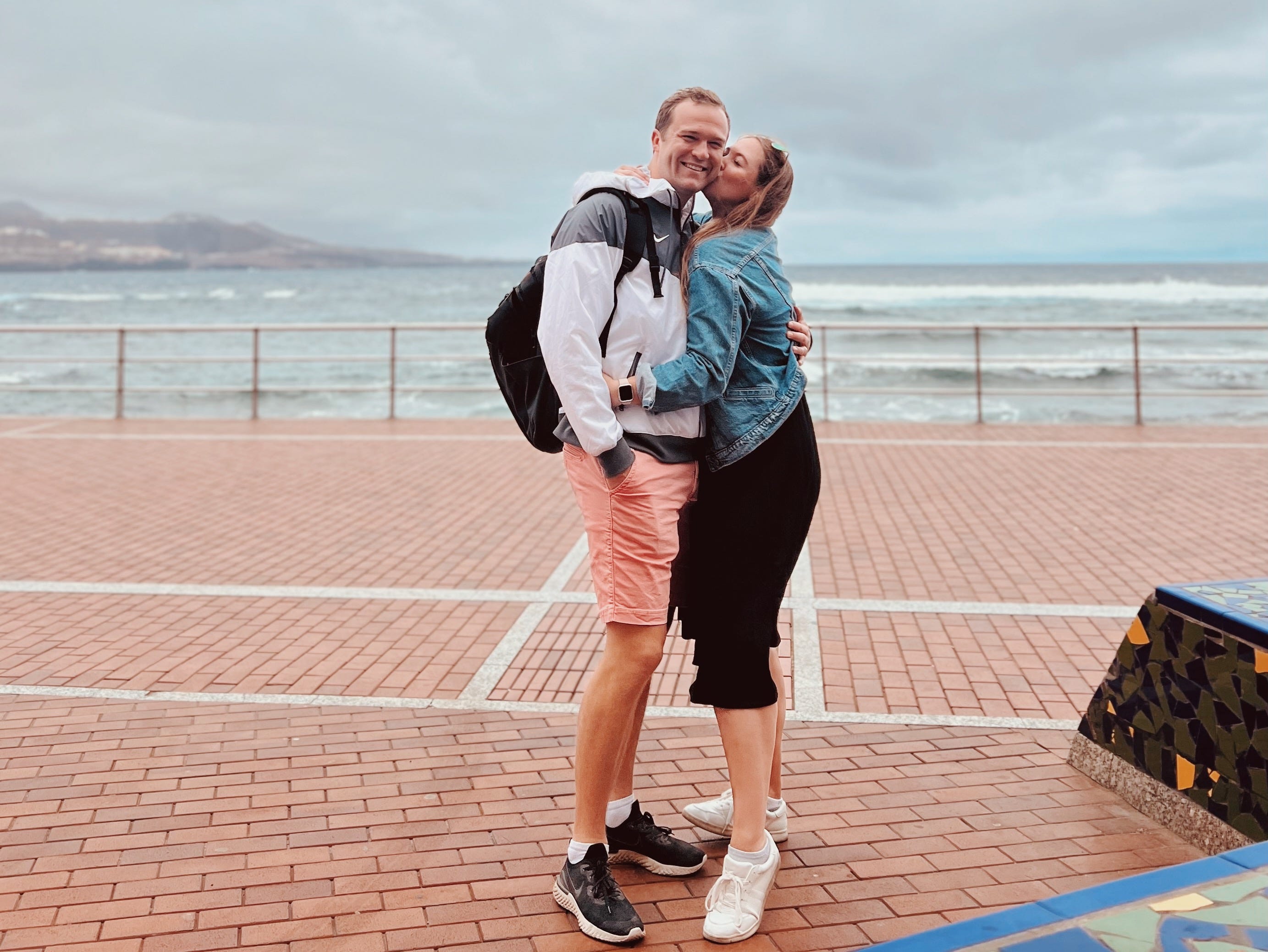 Author Allie Hubers hugging her husband and kissing his cheek in Canary Islands
