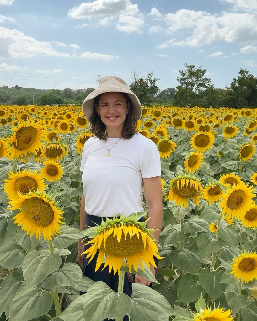 Jennifer Garner smiling in the middle of a sunflower field.
