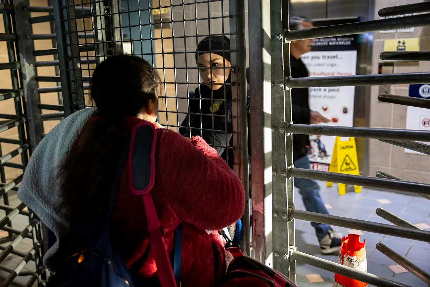 An immigrant speaks to a security officer at the United States border.