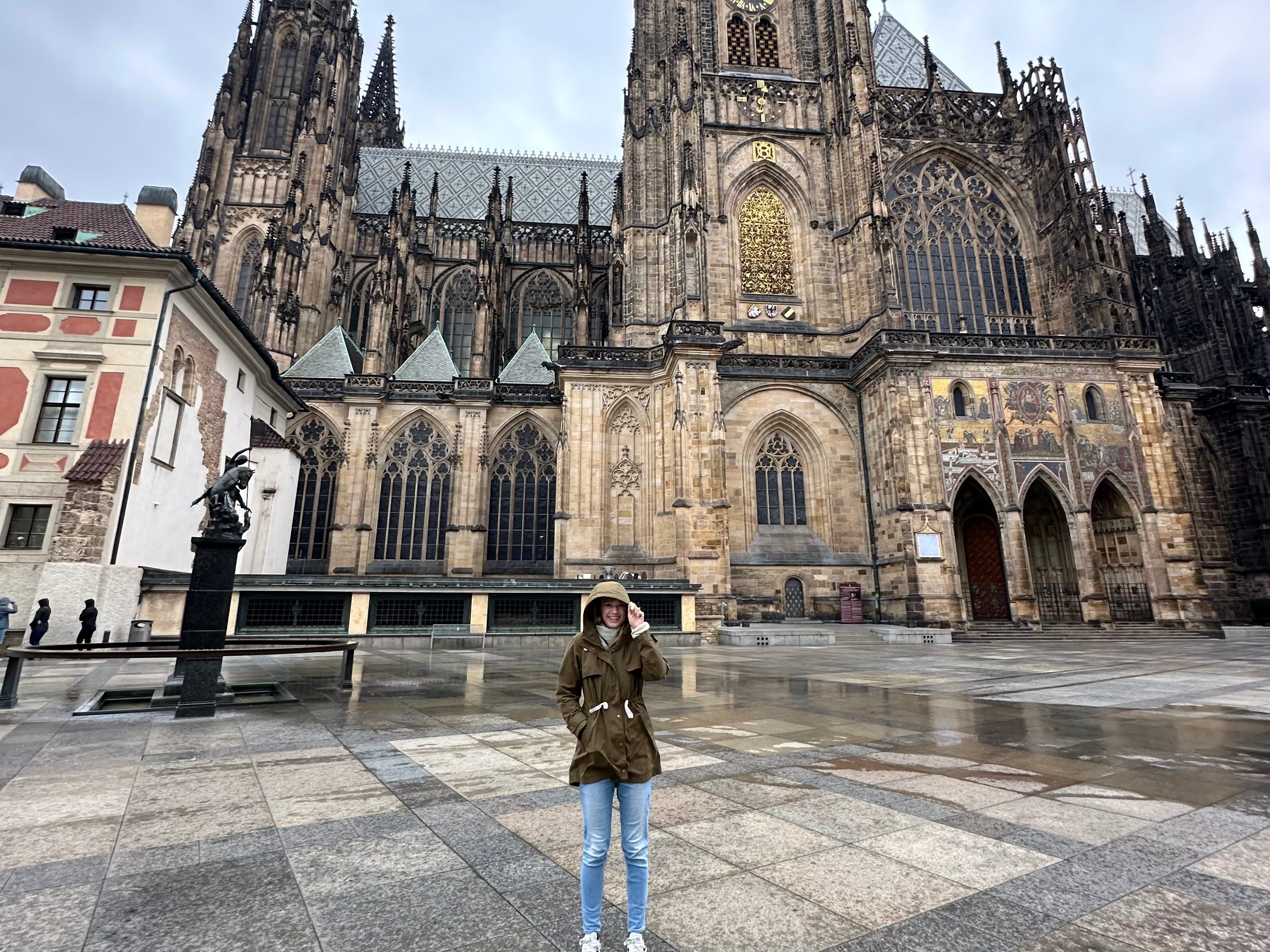 Emily standing in front of a cathedral in the rain.