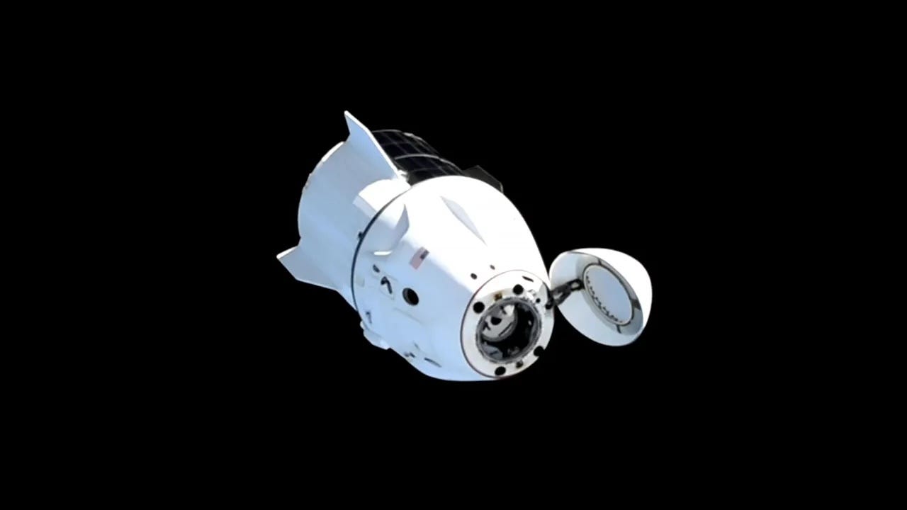 white crew dragon spaceship with nose hatch open in space