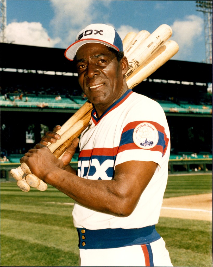 Minny Minoso holding baseball bats.