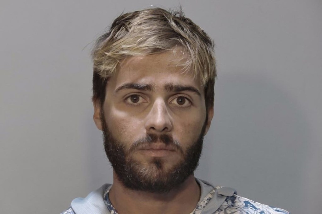 Mugshot of a man with blond and brown hair and a beard.