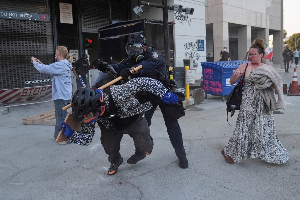 A protester attempts to evade a Department of Homeland Security officer after federal immigration authorities conducted an operation on Friday, June 6, 2025.