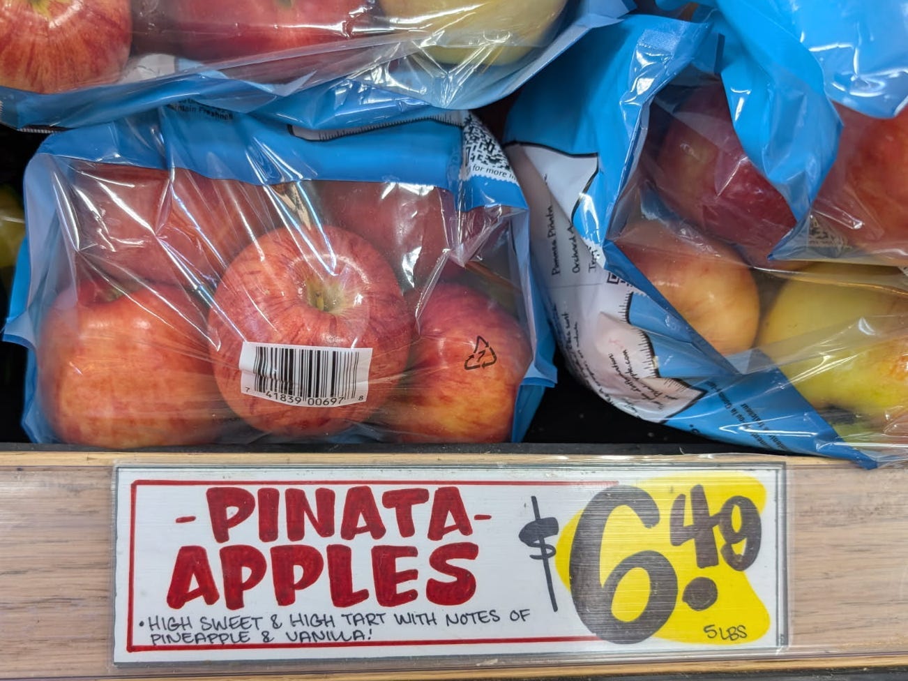 A bag of Piñata apples on the shelf at Trader Joe's.