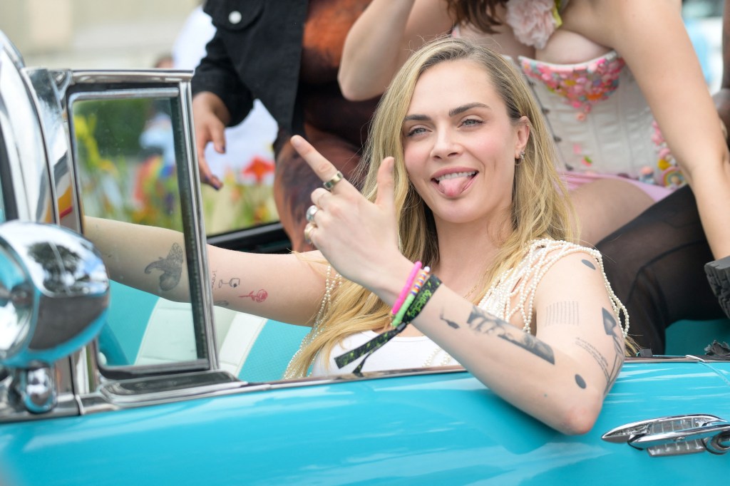 Cara Delevingne is tongues out, guns out at a Pride Parade in West Hollywood, Calif.