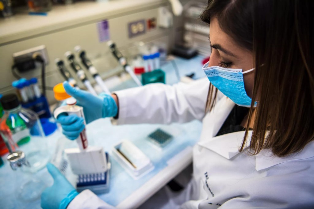Researcher conducting a breast cancer vaccine experiment in a lab.