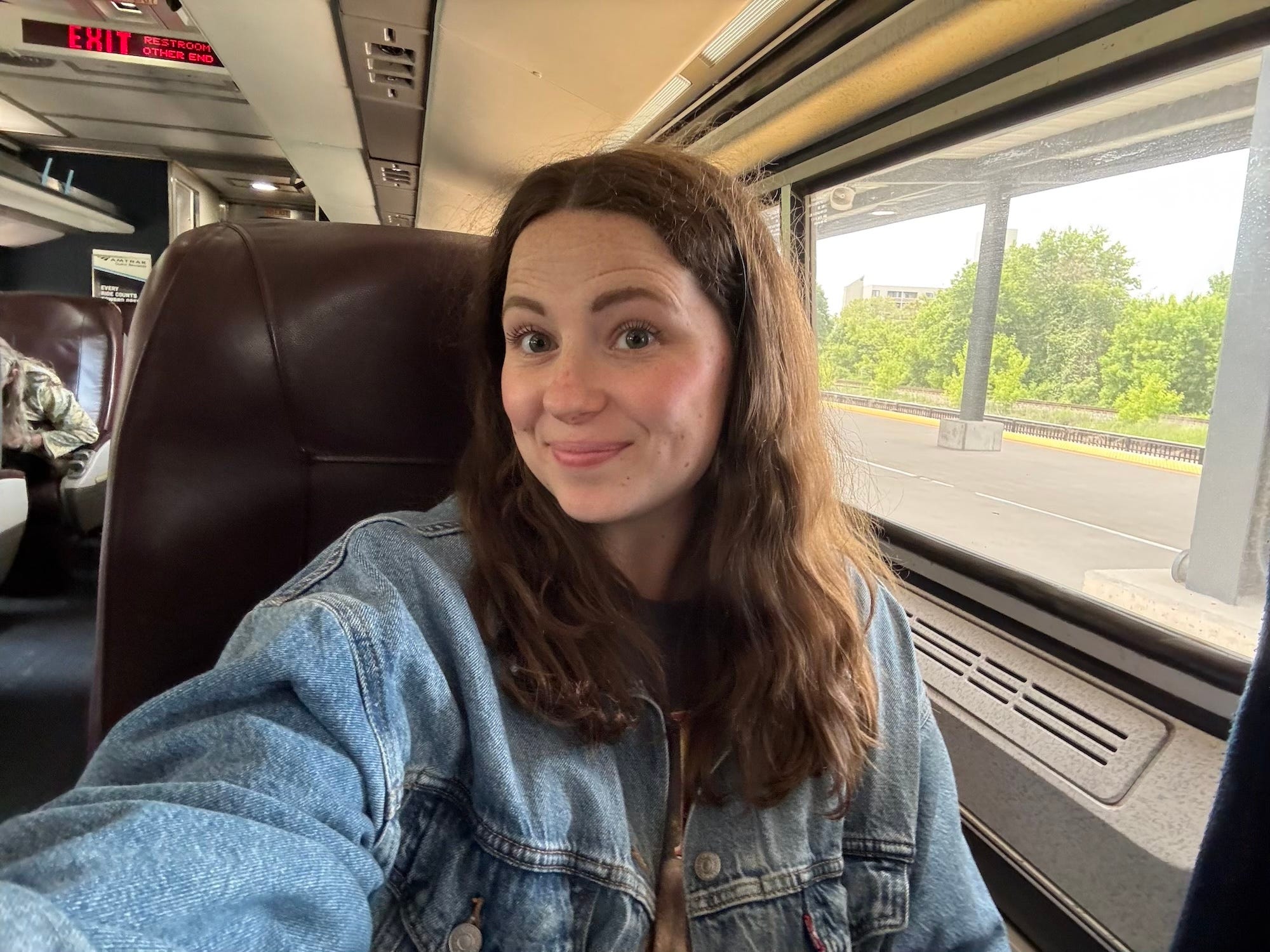 A selfie of a woman sitting on an Amtrak train.