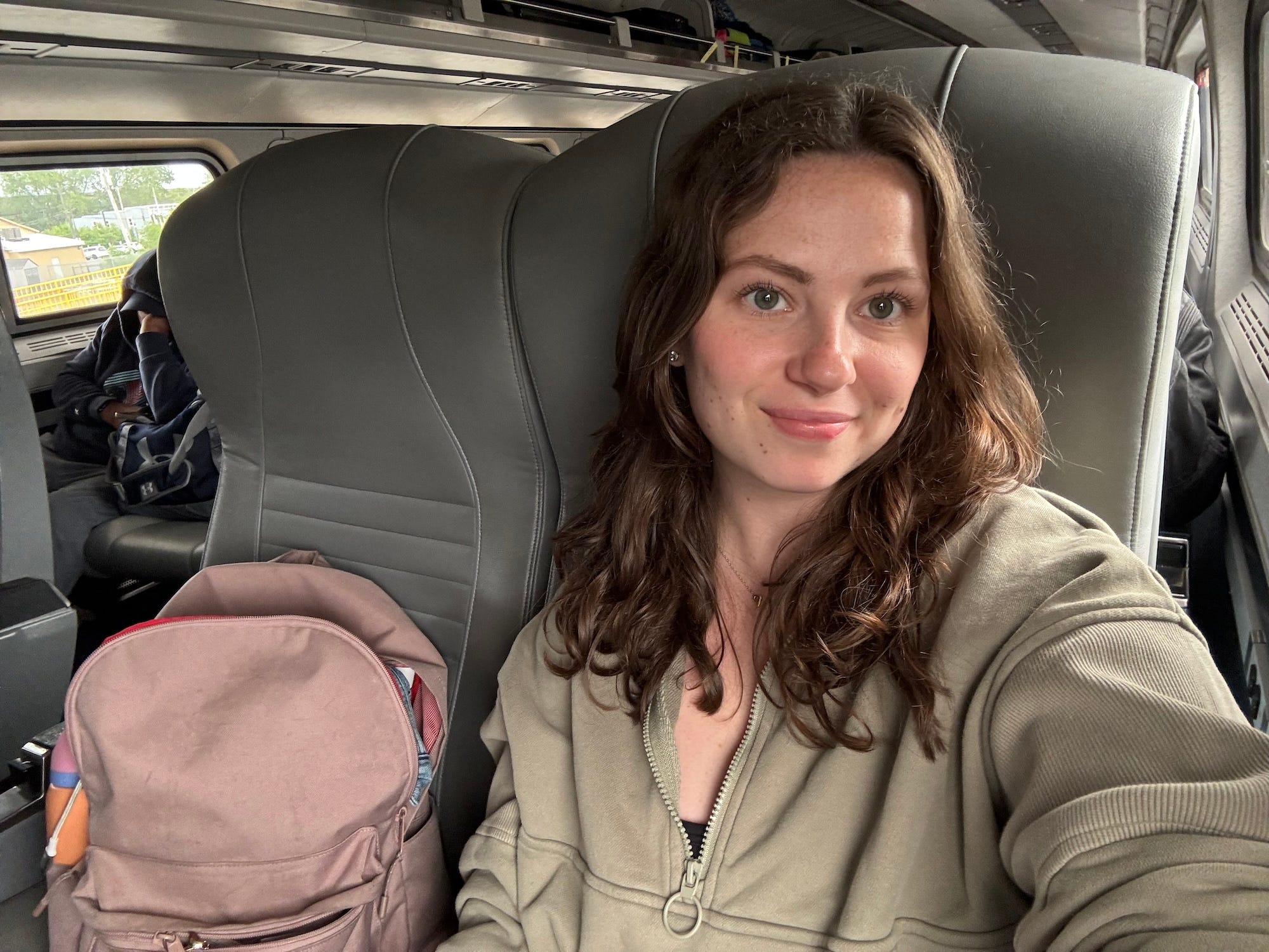 A selfie of a woman sitting on an Amtrak train.