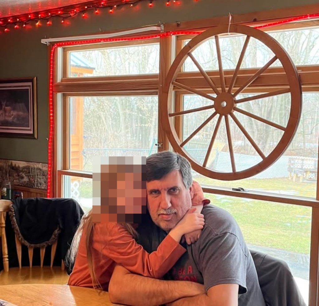Small blonde girl hugging Lyle Mitchell in Facebook photo posted by Joyce Mitchell 
