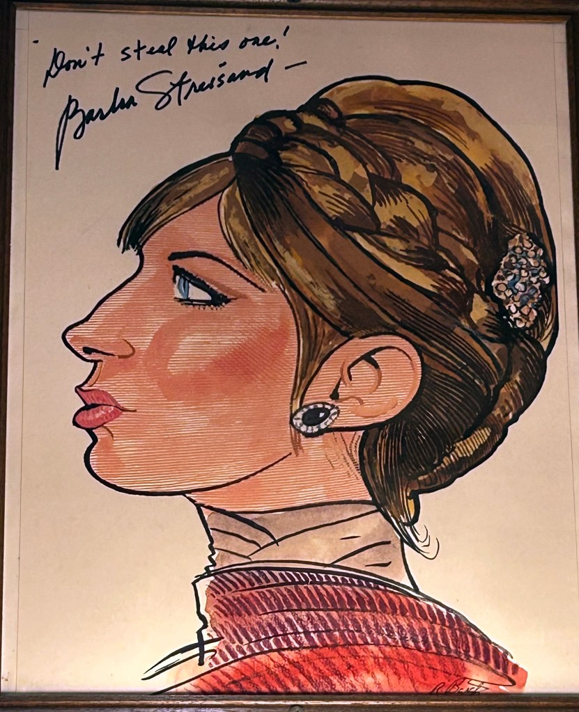 Barbra Streisand caricature at Sardis. in profile with her hair up. streisand wrote don't steal this one! and added her name in the upper left corner
