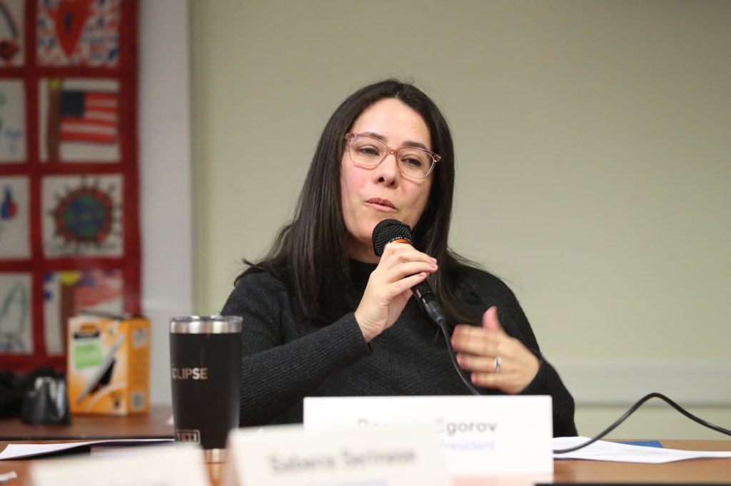Danyela Souza Egorov speaking at a microphone.