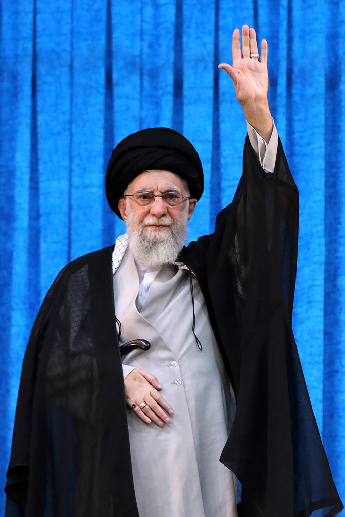 Ayatollah Ali Khamenei waving at a ceremony.