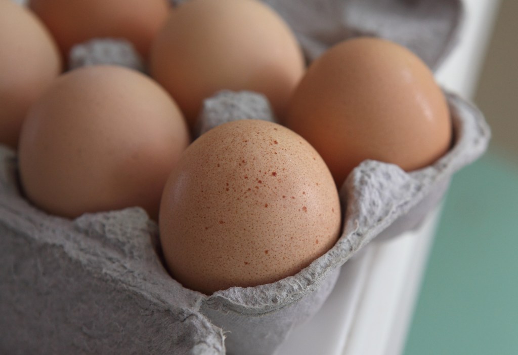 Close-up of brown eggs in a carton.