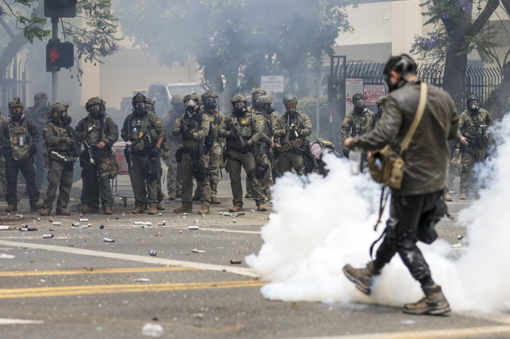 Federal agents clash with protesters during an ICE raid.