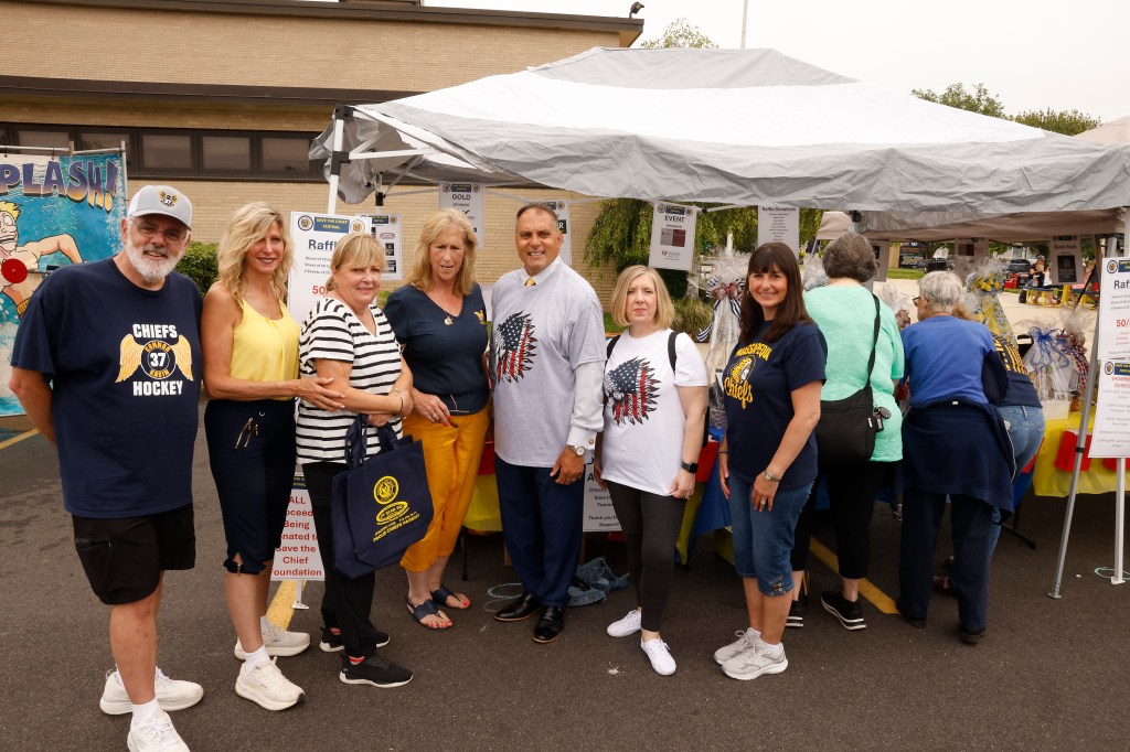 Group of people posing at a Save the Chief festival booth.