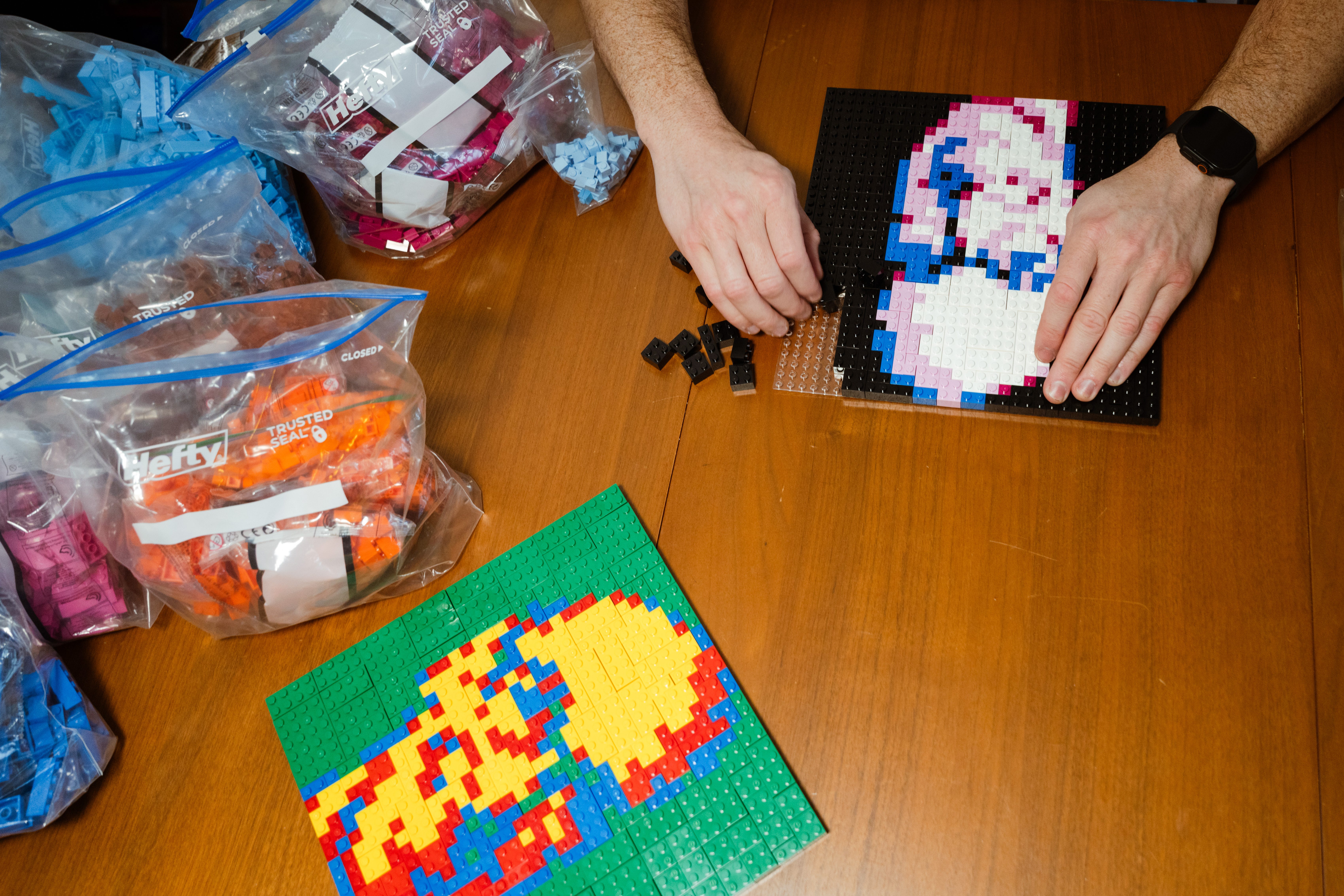 The hands of Albert build a Lego piece