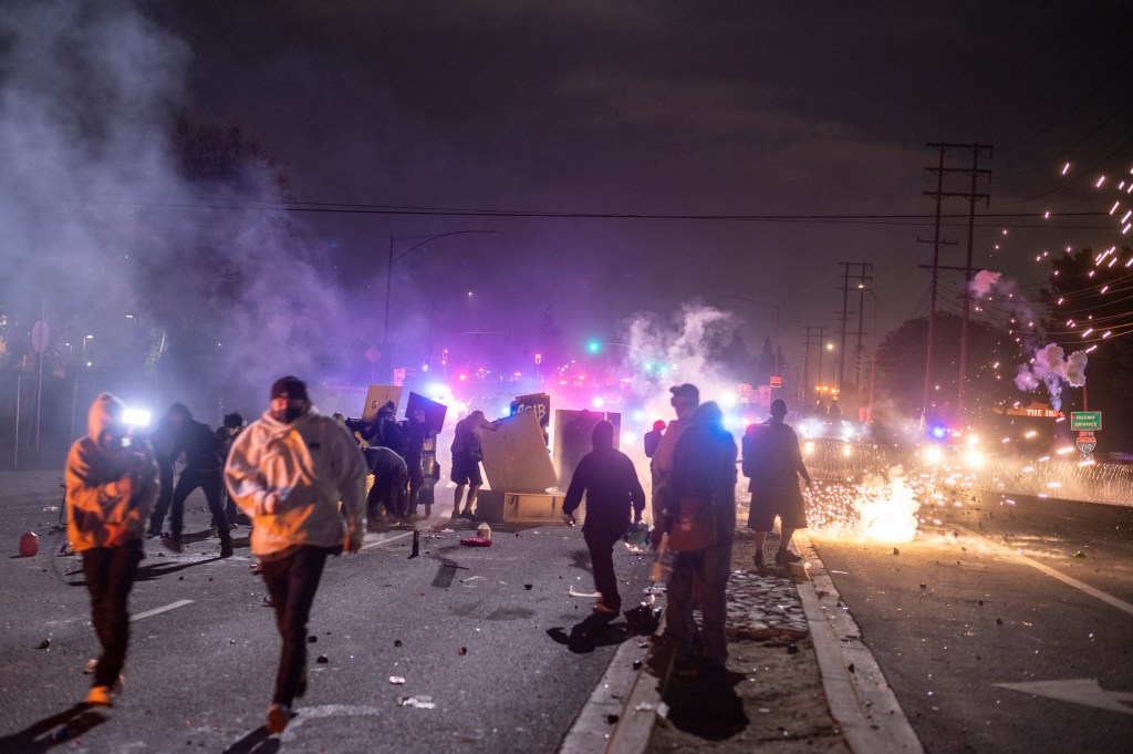 Protesters put up a road block near a fire in the streets of Compton.
