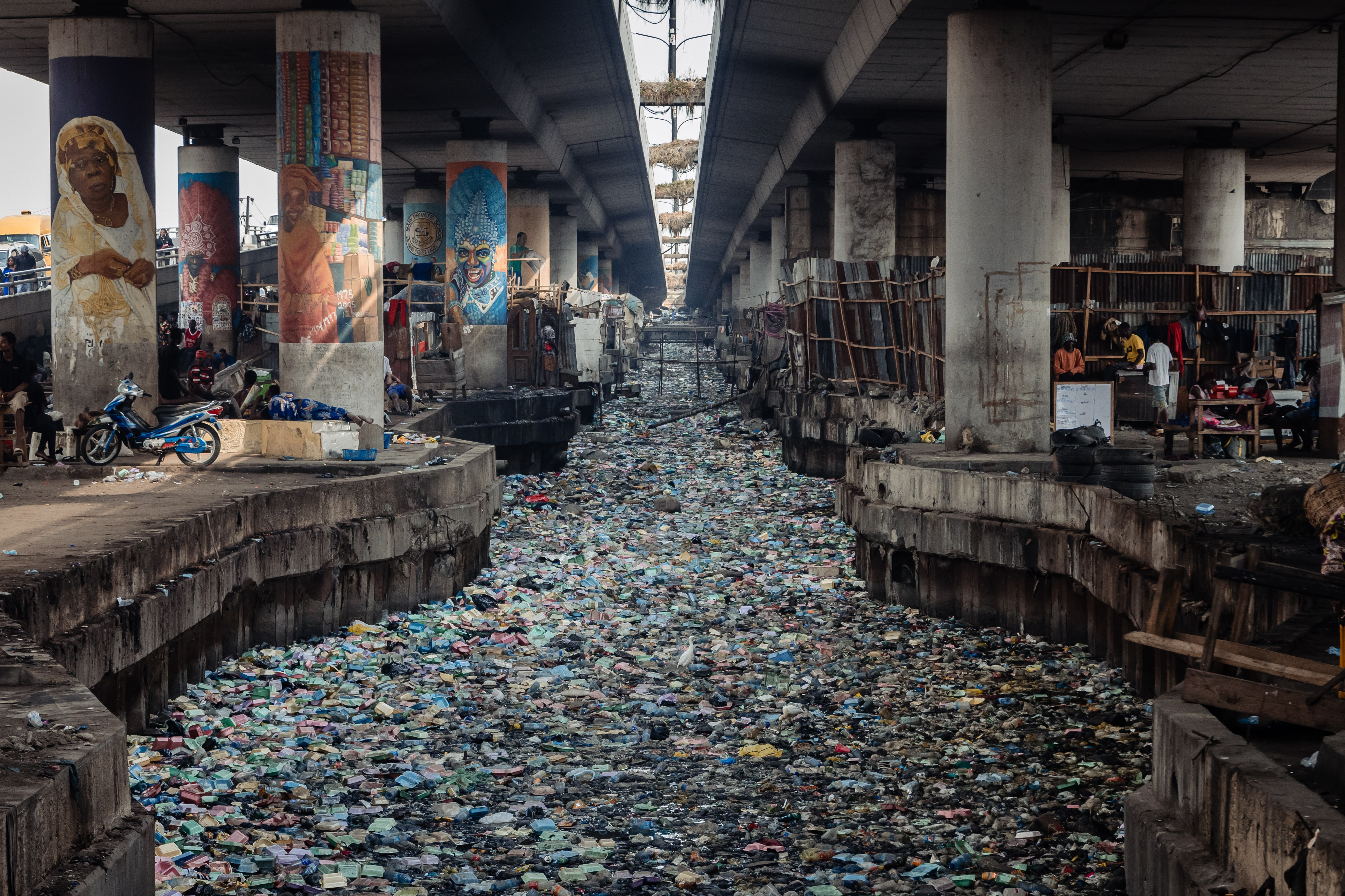 A view of a canal, clogged with styrofoam and single-use plastic