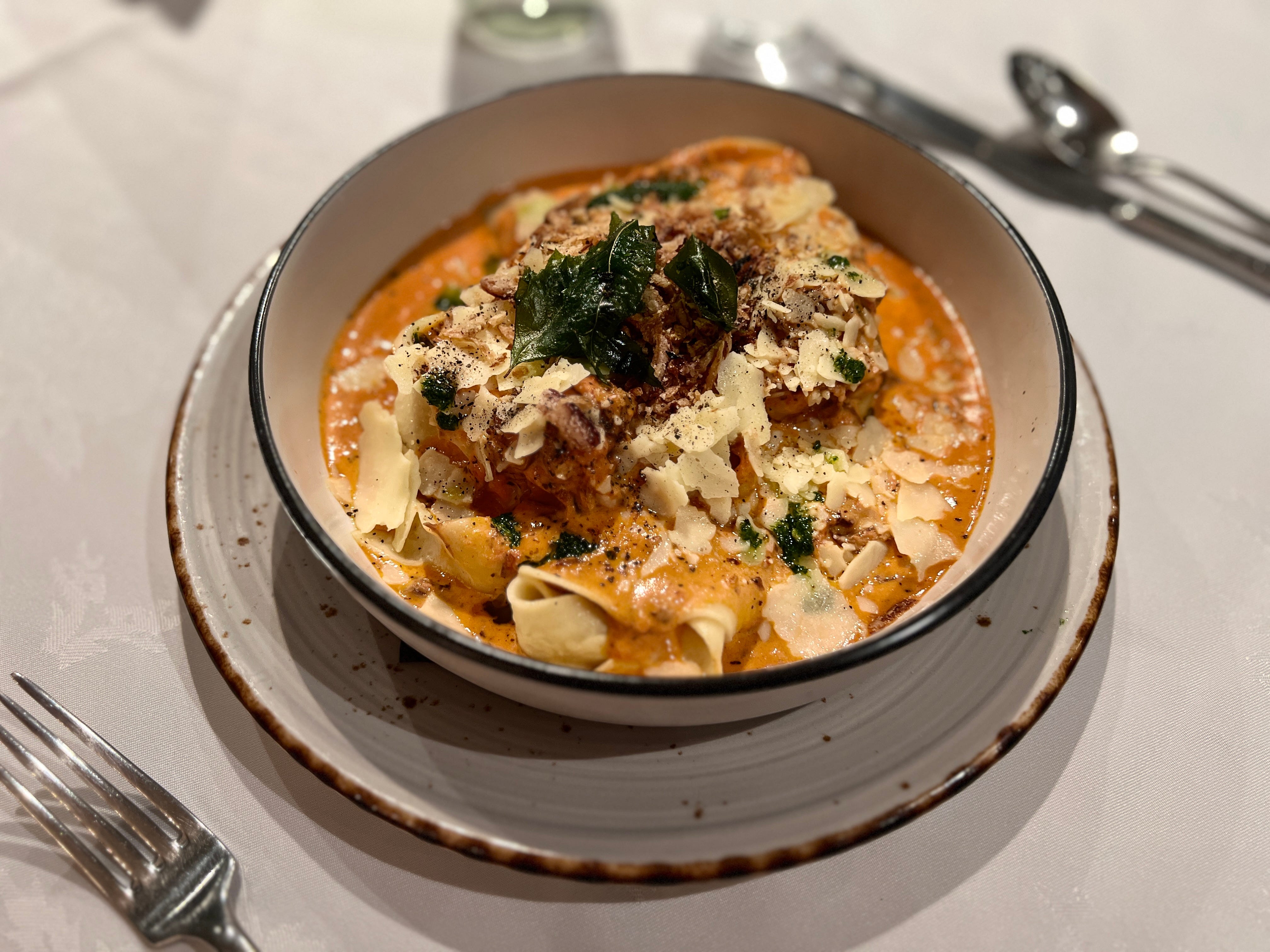 slow-braised beef cheek pasta topped with cheese, greens