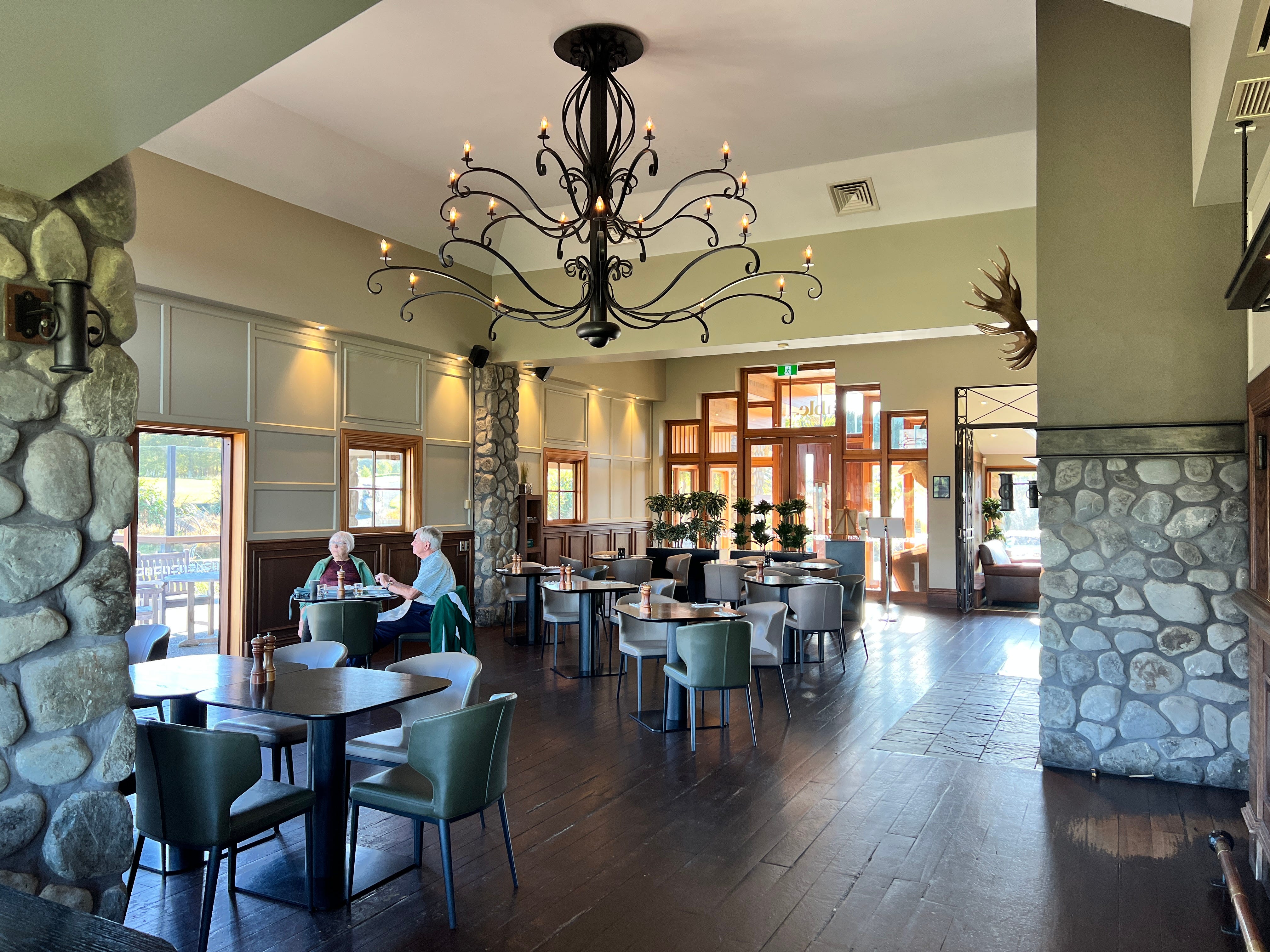Dining area with wood floors, chandelier, tables, leather chairs