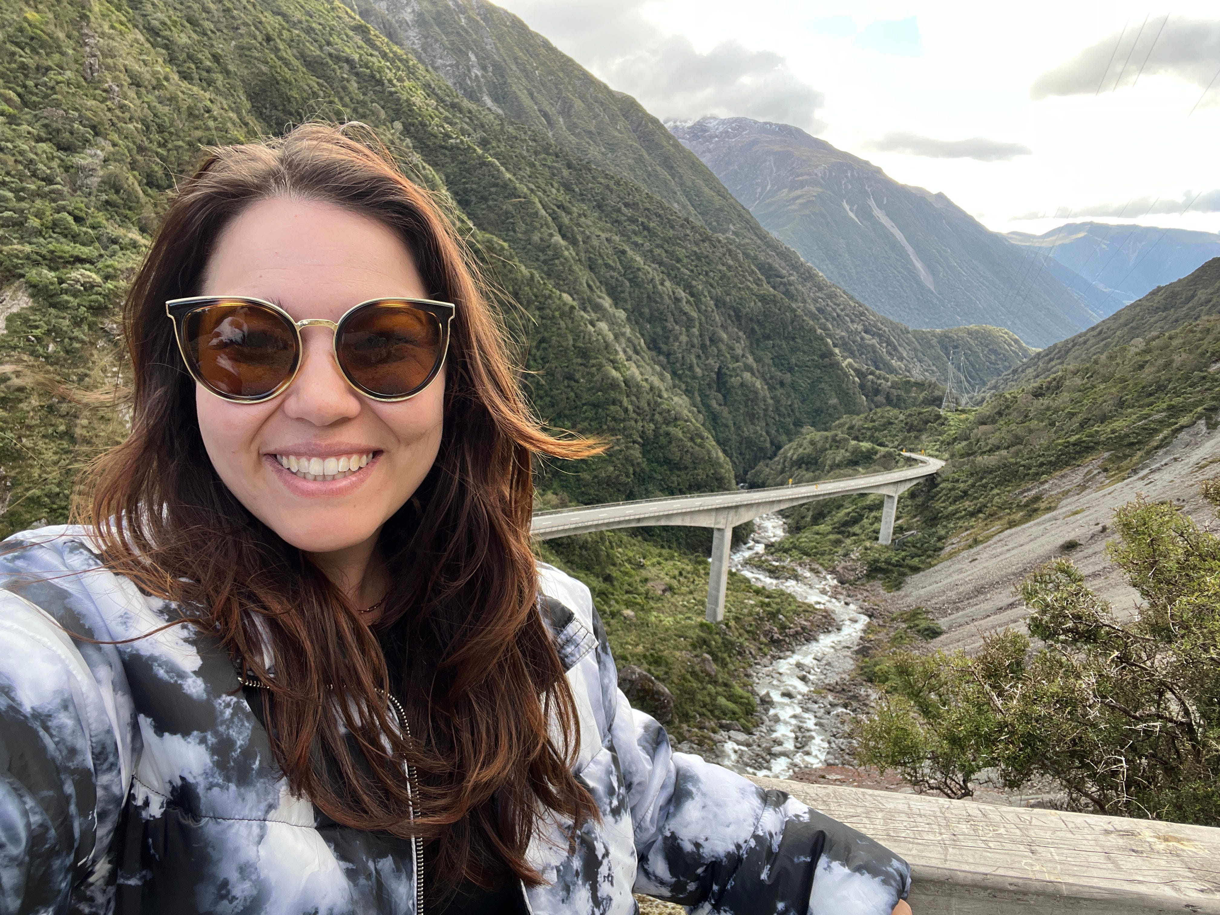 Author Ashley Probst smiling in front of mountains, valleys