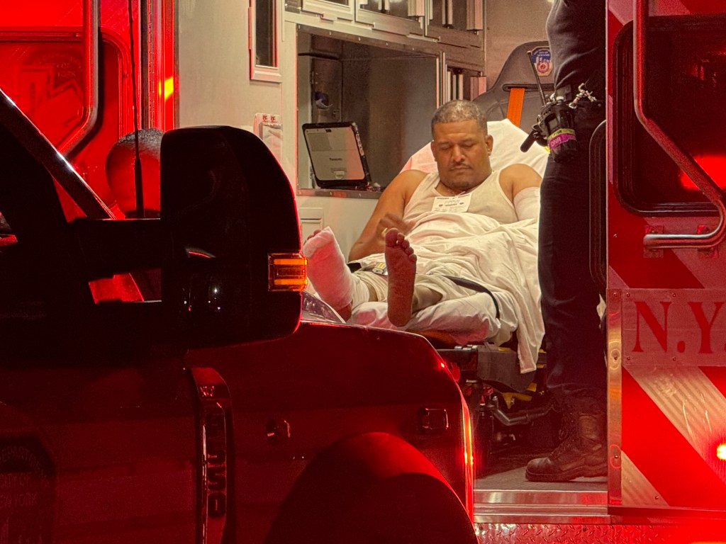 Injured man in an ambulance with a leg cast.
