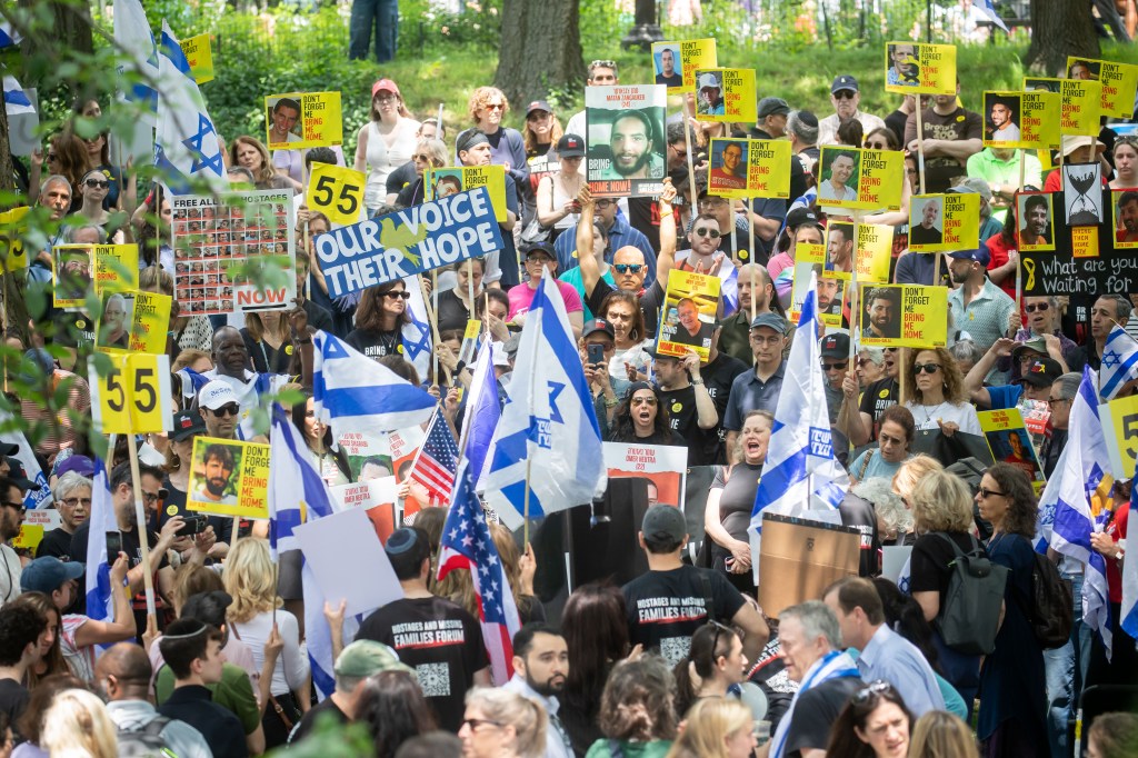 Protestors at a Bring Them Home NOW! march in Central Park hold signs with photos of hostages and missing people.