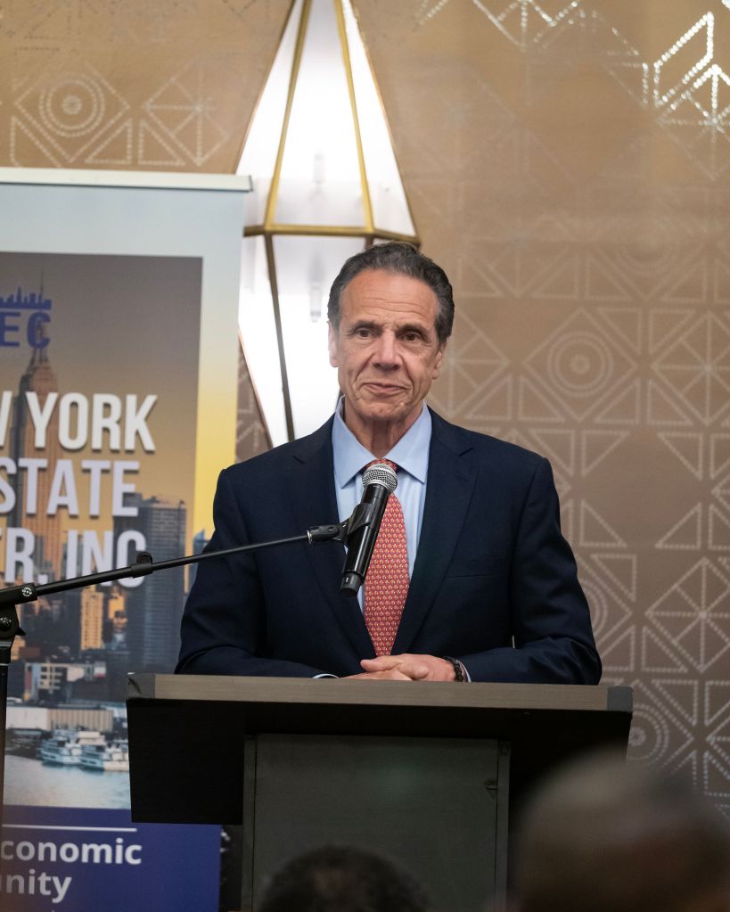Andrew Cuomo speaking at a podium.