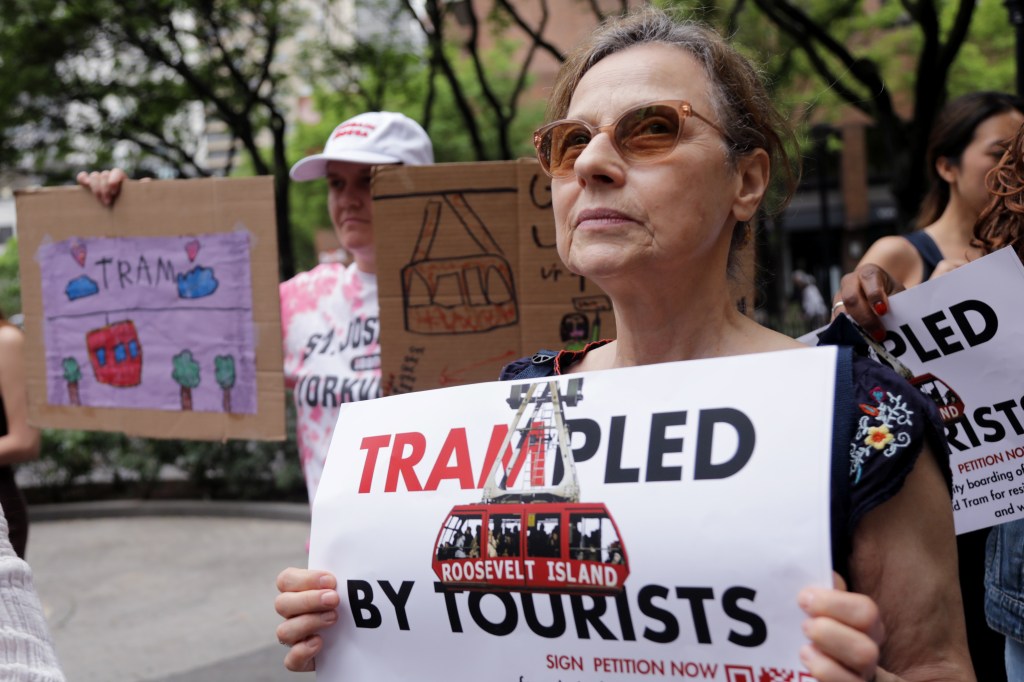Protestors holding signs advocating for priority boarding on the Roosevelt Island Tram.