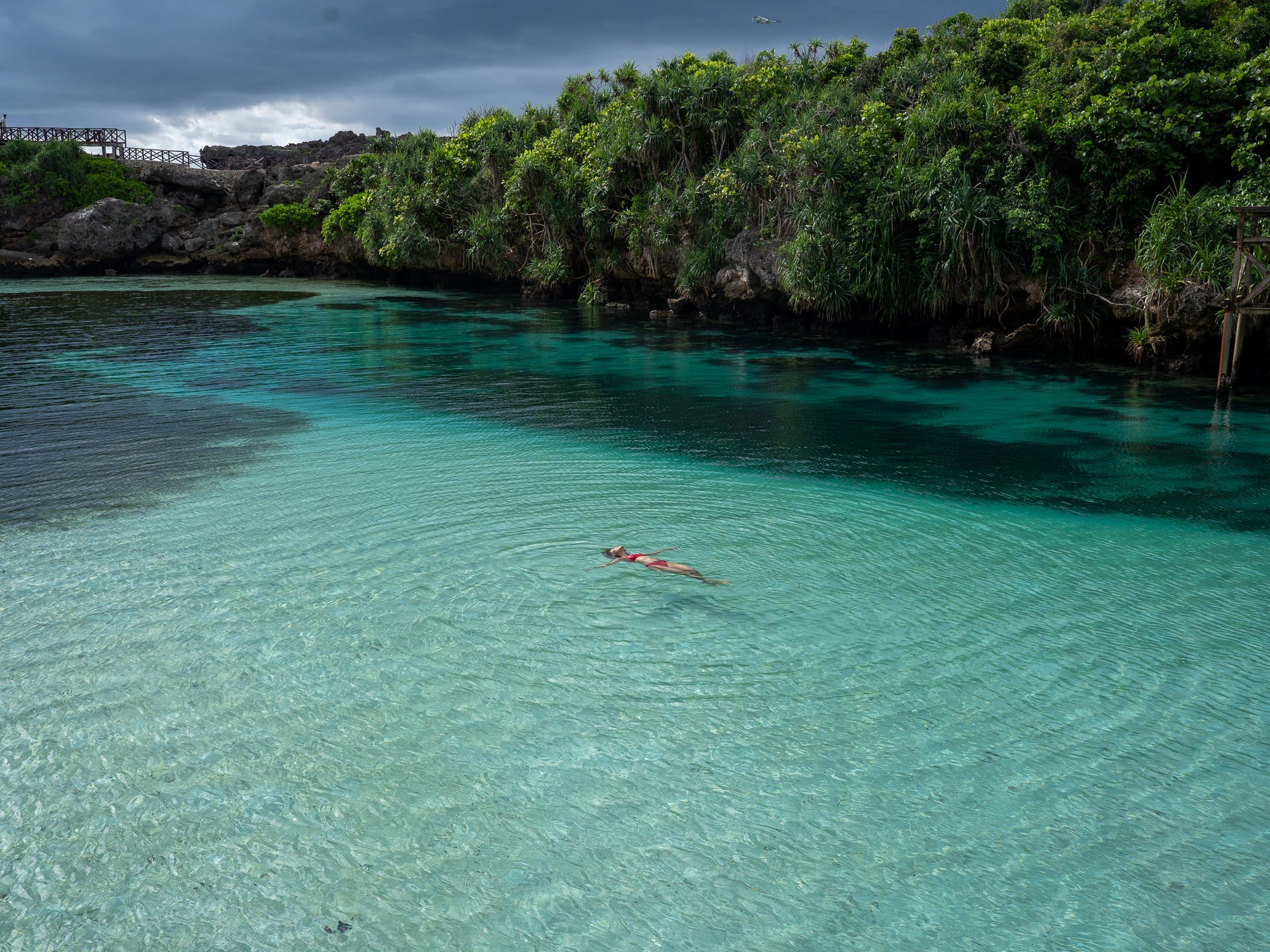 A woman in a. red bikini floating in the Waikuri Lagoon in Sumbai, Indonesia.
