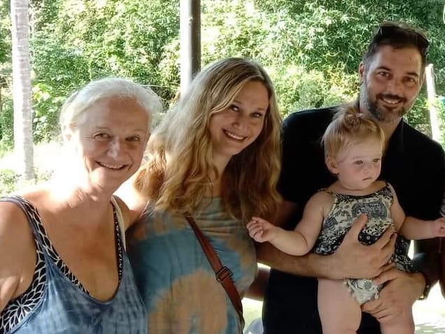 A woman posing for a photo with her mother, her daughter and her husband.
